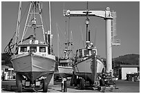 Fishing boats parked on deck with hoist behind, Port Orford. Oregon, USA (black and white)