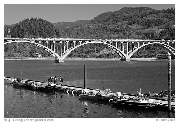 Small boat deck and Rogue River bridge. Oregon, USA (black and white)