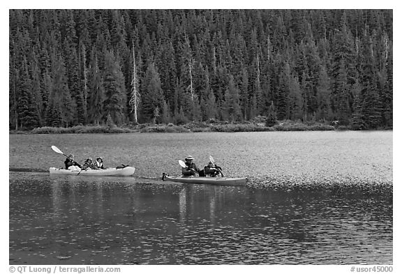 Parents kayaking with children in tow, Devils Lake. Oregon, USA