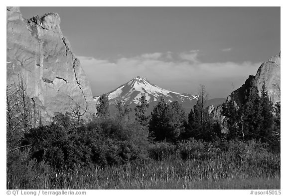 Snow-capped volcano seen between rock pinnacles. Smith Rock State Park, Oregon, USA (black and white)