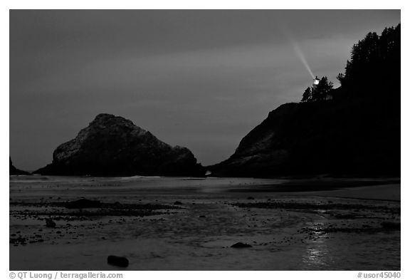 Heceta Head and lighthouse beam from beach by night. Oregon, USA (black and white)