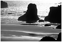 Rocks, water reflections, and beach, late afternoon. Bandon, Oregon, USA (black and white)