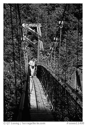 Woman hiking on suspension bridge, Lava Canyon. Mount St Helens National Volcanic Monument, Washington