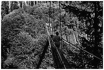 Hiker walks on suspension bridge, Lava Canyon. Mount St Helens National Volcanic Monument, Washington (black and white)