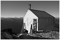 Man standing in doorway of Hidden Lake lookout. Washington (black and white)