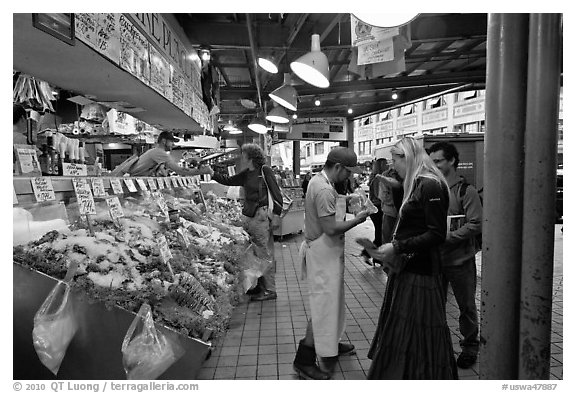 Countermen offer fish samples, Pike Place Market. Seattle, Washington (black and white)