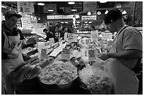 Countermen unloading seafood,  Pike Place Market. Seattle, Washington (black and white)