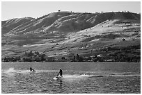 Personal watercraft riders and vineyard covered hills, Lake Chelan. Washington ( black and white)