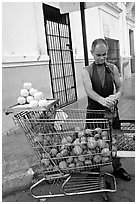 A man peels oranges to make an orange drink, which is drunk from the fruit itself, Ponce. Puerto Rico (black and white)