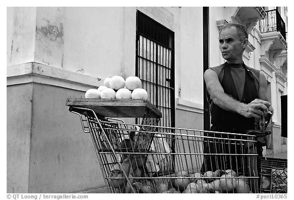 Man peeling oranges to make a drink, drunk from the fruit itself, Ponce. Puerto Rico (black and white)
