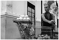 Man peeling oranges to make a drink, drunk from the fruit itself, Ponce. Puerto Rico ( black and white)