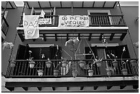 Facade of house painted in blue with pots, balconies and anti-war signs. San Juan, Puerto Rico (black and white)