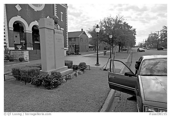 African-American man sitting in car looking at Martin Luther King memorial. Selma, Alabama, USA (black and white)