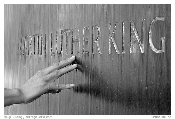 Hand touching the letters Martin Luther King in flowing water. Montgomery, Alabama, USA (black and white)