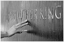 Hand touching the letters Martin Luther King in flowing water. Montgomery, Alabama, USA (black and white)