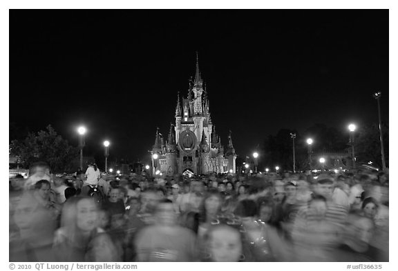Crowds on Main Street with castle in the back at night. Orlando, Florida, USA (black and white)