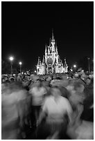 Crowds walking away from Cinderella Castle at night. Orlando, Florida, USA (black and white)