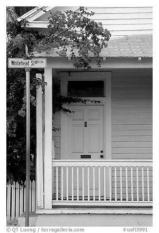 Pastel-colored house, tropical flowers, street sign. Key West, Florida, USA (black and white)