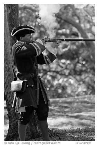 Man in period costume fires smooth bore musket, Fort Matanzas National Monument. St Augustine, Florida, USA (black and white)