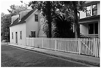 White picket fence and houses on cobblestone street. St Augustine, Florida, USA (black and white)