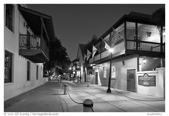 Old street and historic buildings with flags by night. St Augustine, Florida, USA (black and white)