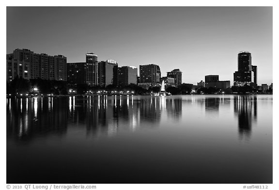 Orlando skyline at sunset reflected in lake Eola. Orlando, Florida, USA