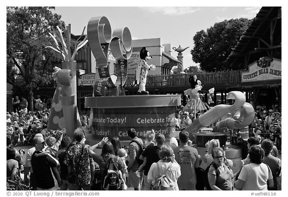 Crowds attends parade with Mickey and Minnie characters. Orlando, Florida, USA (black and white)