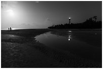 Lighthouse beach with family in distance and moonlight, Sanibel Island. Florida, USA ( black and white)