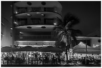 Restaurant tables and Art Deco buildings at night, Miami Beach. Florida, USA ( black and white)