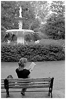 Woman reading a book in front of Forsyth Park Fountain. Savannah, Georgia, USA (black and white)