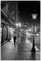 People on sidewalk of River Street by night. Savannah, Georgia, USA (black and white)