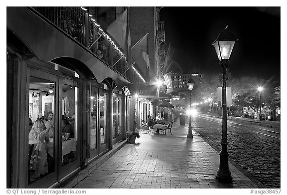 Restaurant, lamps, and sidewalk of River Street by night. Savannah, Georgia, USA (black and white)