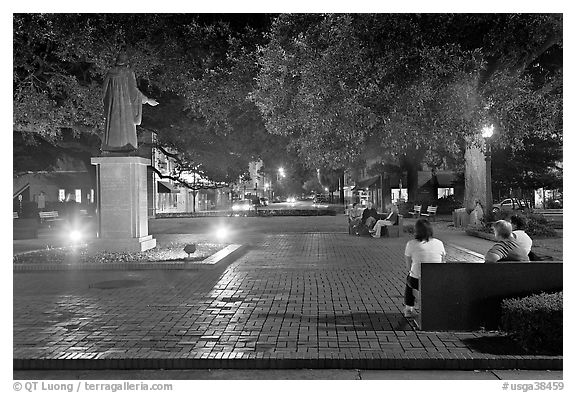 Square by night with people sitting on benches. Savannah, Georgia, USA (black and white)