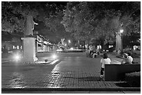 Square by night with people sitting on benches. Savannah, Georgia, USA (black and white)