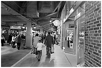 Family walking in front of Underground Atlanta store with historic brick wall. Atlanta, Georgia, USA ( black and white)