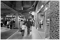 Family walking in front of Underground Atlanta store with historic brick wall. Atlanta, Georgia, USA (black and white)