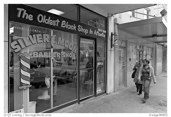 Women walking in front of oldest black shop in Atlanta. Atlanta, Georgia, USA (black and white)