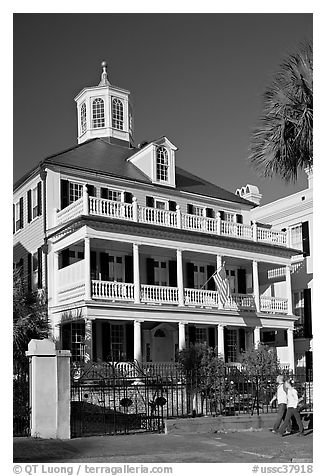 Couple walking in front of antebellum house. Charleston, South Carolina, USA (black and white)