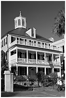 Couple walking in front of antebellum house. Charleston, South Carolina, USA (black and white)