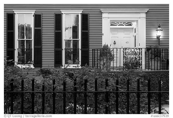 House facade at dusk with roses in front yard. Charleston, South Carolina, USA