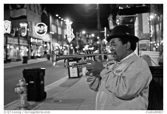African-American man playing trumpet on Beale Street by night. Memphis, Tennessee, USA (black and white)