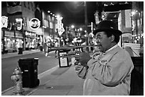 African-American man playing trumpet on Beale Street by night. Memphis, Tennessee, USA (black and white)