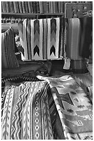 Stacks of varicolored blankets and rugs weaved by Navajo Indians. Hubbell Trading Post National Historical Site, Arizona, USA (black and white)