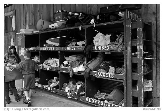 Family tries out clothes from sharing box. Telluride, Colorado, USA (black and white)