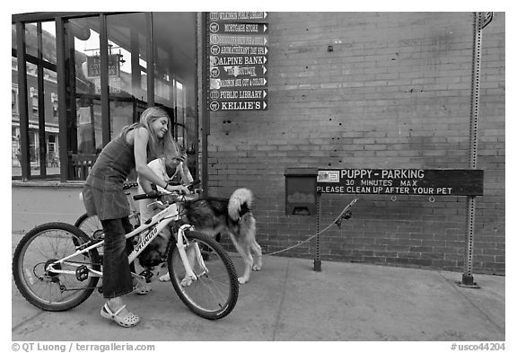 Girls on bikes and puppy parking. Telluride, Colorado, USA