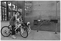 Girls on bikes and puppy parking. Telluride, Colorado, USA (black and white)