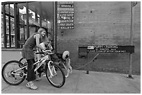 Girls on bikes and puppy parking. Telluride, Colorado, USA (black and white)