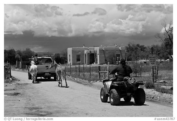 Rural road on the reservation with ATV, truck and horse. Taos, New Mexico, USA (black and white)