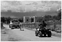 Rural road on the reservation with ATV, truck and horse. Taos, New Mexico, USA (black and white)