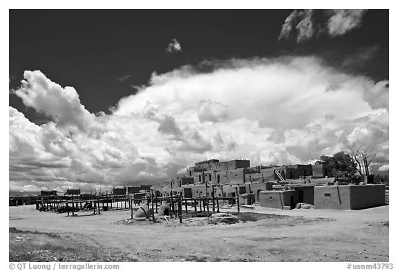 Afternoon cloud hovering over multi-family houses built by Pueblo Indians. Taos, New Mexico, USA (black and white)